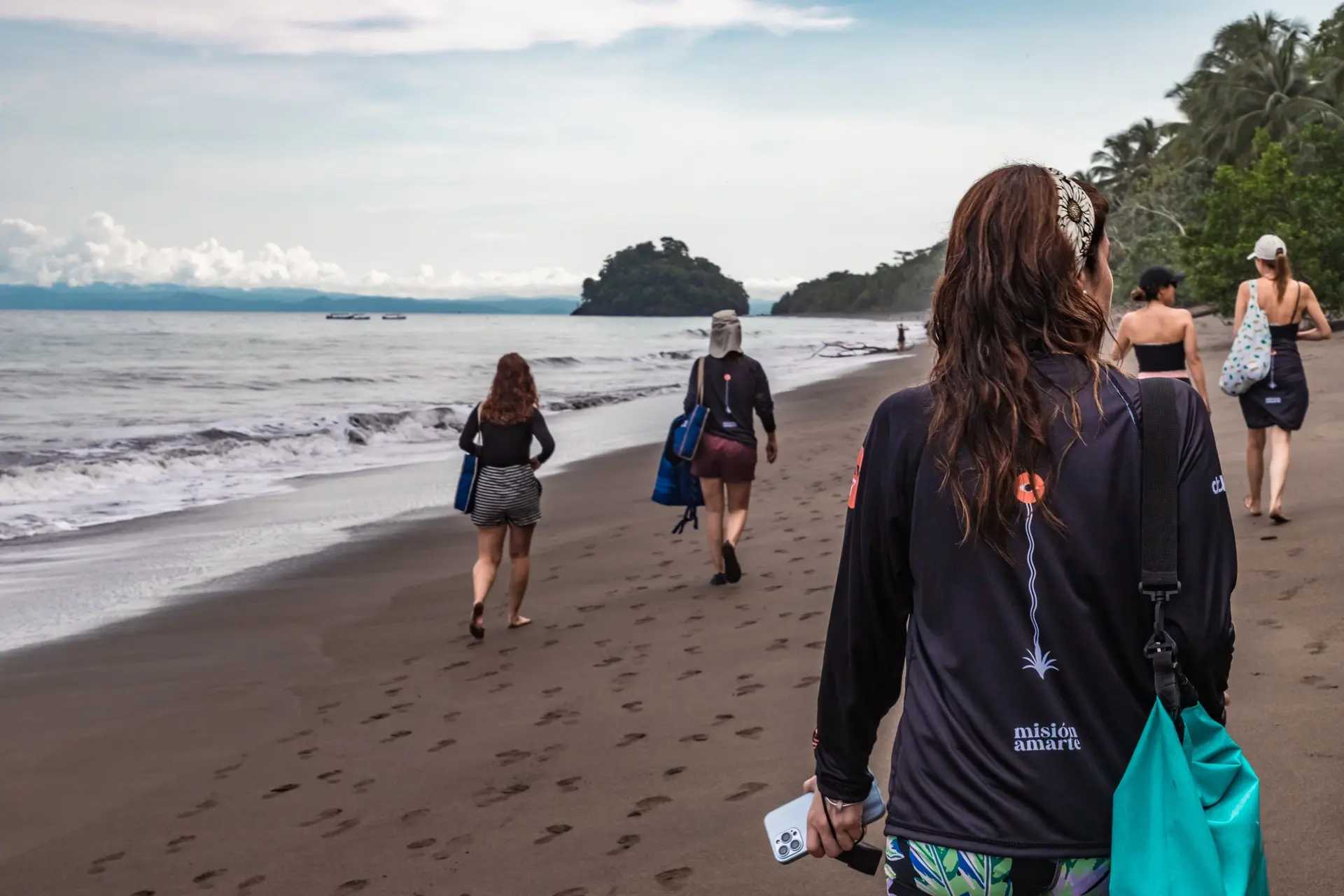 Group walking along the Pacific coast beach in Nuquí